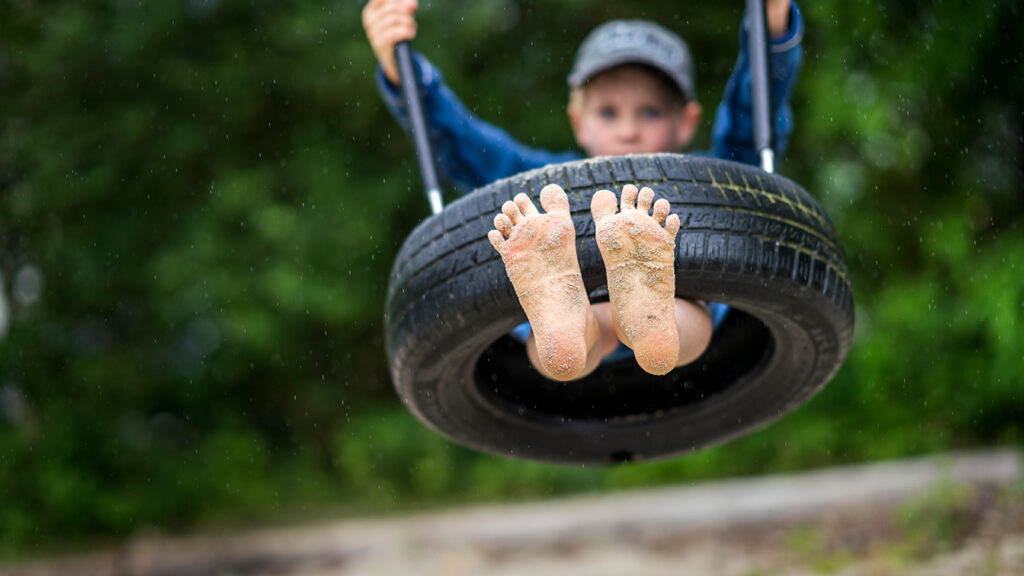 NORNA PLAYGROUNDS - designed for sustainable and creative play, boy in climbing net on natural playground equipment